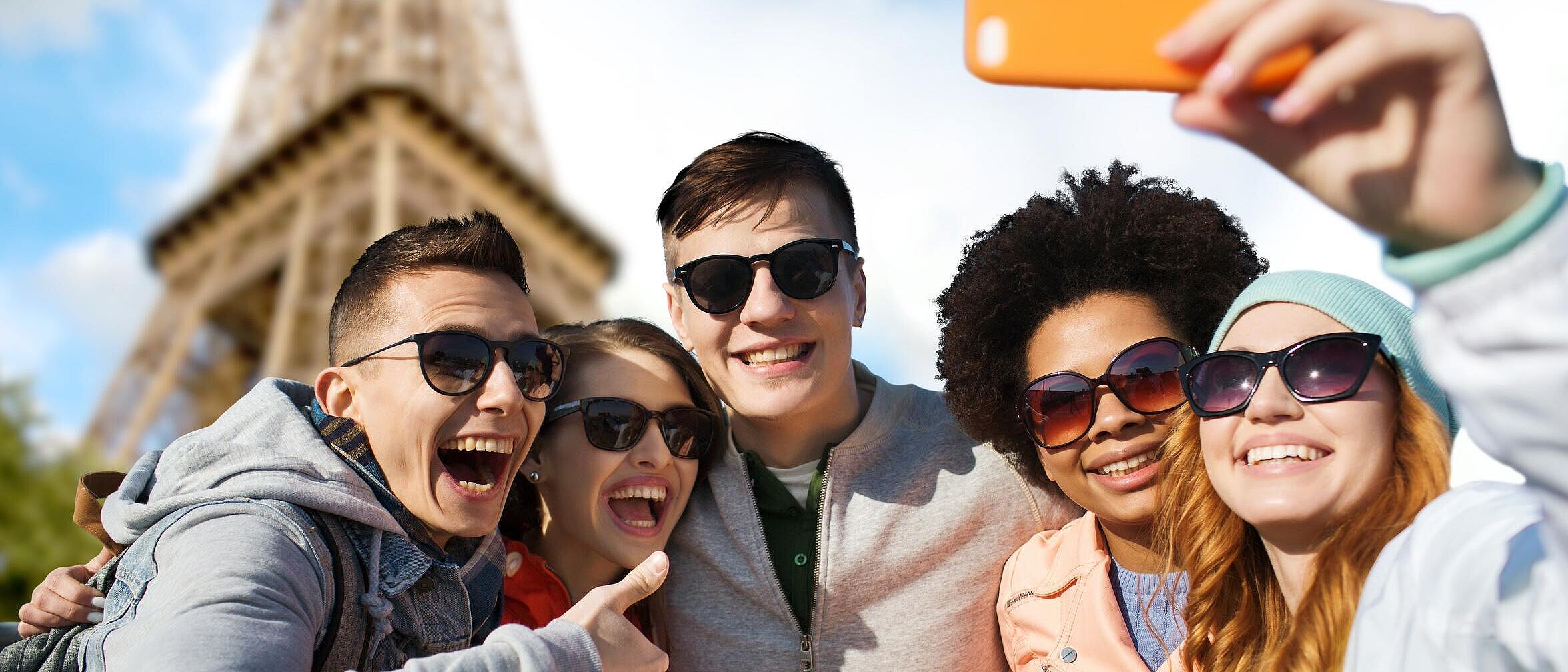 5 lächelnde Freunde mit Sonnenbrillen, die Selfie mit Smartphone machen, im Hintergrund der Eifelturm