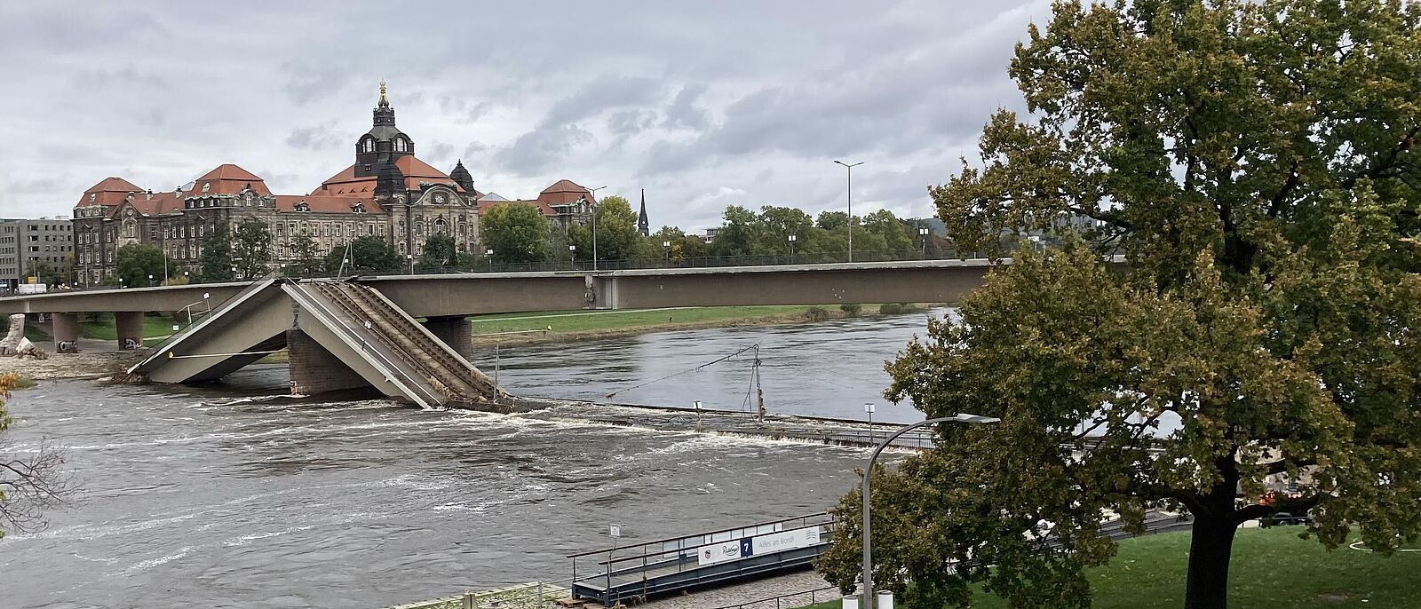 Schräger Blick auf die eingestürzte Carolabrücke von der Altstädter Seite (Anlegestelle der Dampfschifffahrt) in Richtung Neustädter Seite, im Hintergrund ist das Gebäude des Sächsischen Ministerium zu sehen.