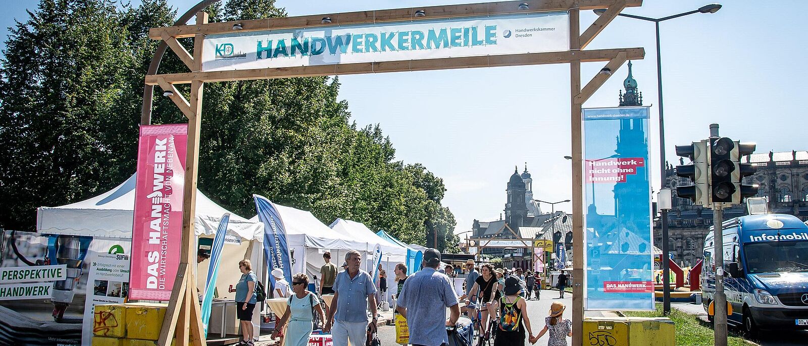 Blick auf den Eingangsbereich zu einem Dresdner Stadtfest der \"Handwerkermeile\". Dieser ist mit regionalen Motiven der Imagekampagne umrahmt \"Handwerk – nicht ohne Innung!\"