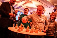 Impressionen vom Workshops wurden im Rahmen der Auftaktveranstaltung Selbstständig Lausitz – mehrere Personen stehen um einen Tisch auf dem sich eine Art Schachfiguren befinden, eine Person referiert dazu.